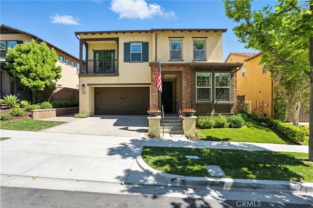 12 Rastro St, Rancho Mission Viejo, CA 92694 - view of front facade with stucco siding, a balcony, driveway, a garage, and a front yard