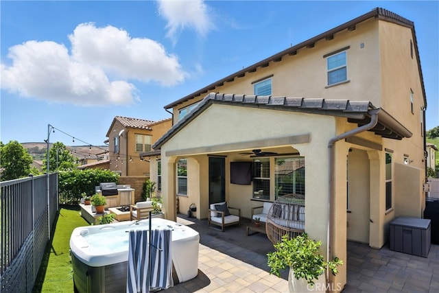 12 Rastro St, Rancho Mission Viejo, CA 92694 - rear view of house with a hot tub, a patio, stucco siding, and a fenced backyard