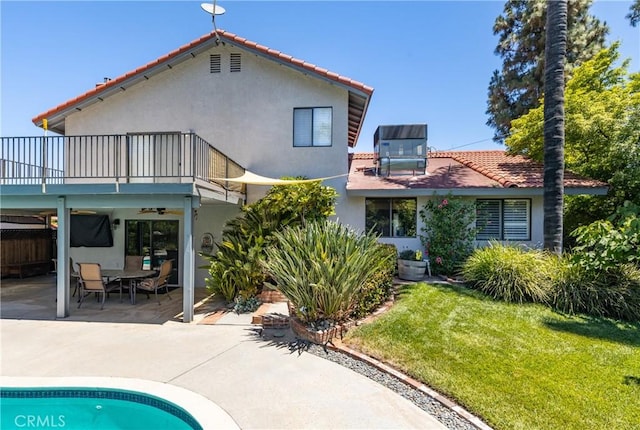 36151 Sharon Way, Yucaipa, CA 92399 - back of house featuring a balcony, stucco siding, a lawn, a patio area, and a tiled roof