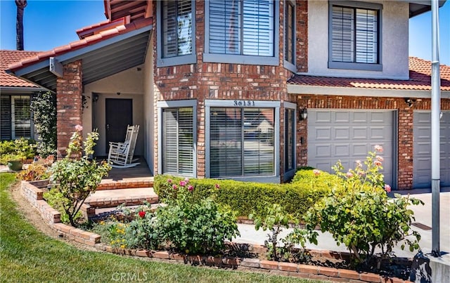 36151 Sharon Way, Yucaipa, CA 92399 - entrance to property featuring stucco siding, brick siding, a garage, driveway, and a tiled roof