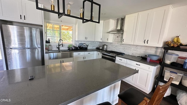 325 Del Sur Way, Oxnard, CA 93033 - kitchen with appliances with stainless steel finishes, wall chimney range hood, backsplash, white cabinetry, and decorative light fixtures