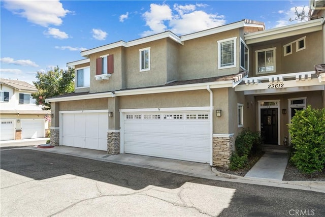23612 Muir Trl Unit 74, Valencia, CA 91354 - townhome / multi-family property with stone siding, stucco siding, and an attached garage