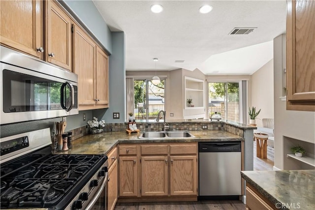 23612 Muir Trl Unit 74, Valencia, CA 91354 - kitchen featuring appliances with stainless steel finishes, a peninsula, dark countertops, plenty of natural light, and recessed lighting