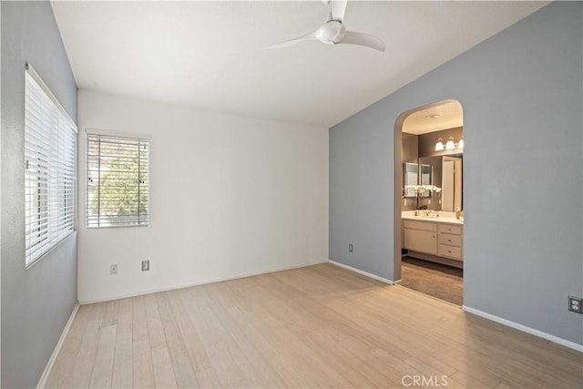 23612 Muir Trl Unit 74, Valencia, CA 91354 - unfurnished bedroom with light wood finished floors, arched walkways, ensuite bath, and a ceiling fan
