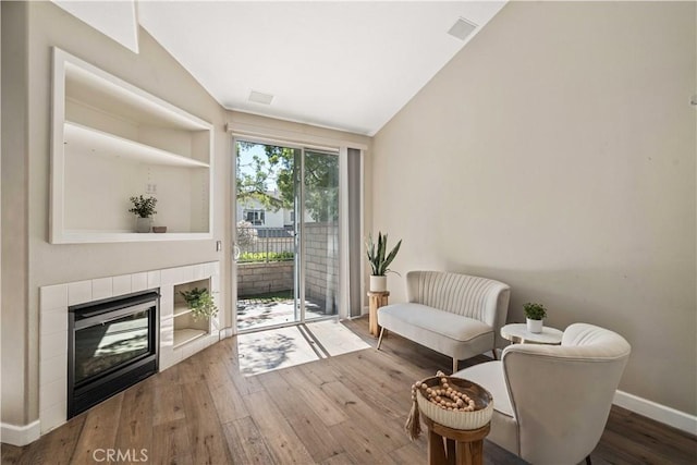 23612 Muir Trl Unit 74, Valencia, CA 91354 - living area featuring lofted ceiling, wood-type flooring, and a tiled fireplace
