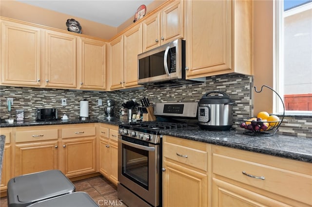 29063 Boulder Crest Way, Menifee, CA 92584 - kitchen with appliances with stainless steel finishes, light brown cabinetry, tasteful backsplash, dark tile patterned flooring, and dark stone counters
