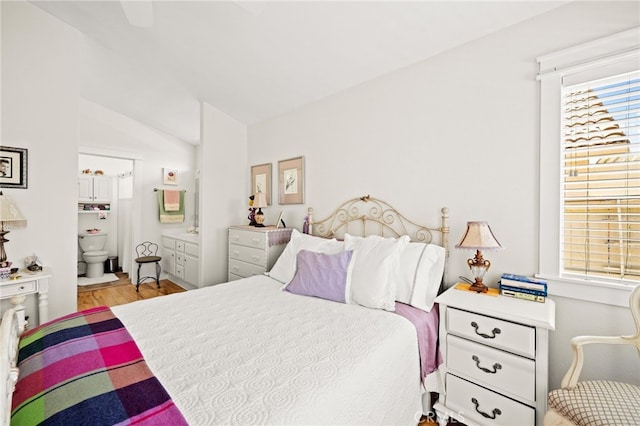 23974 Via Astuto, Murrieta, CA 92562 - bedroom with lofted ceiling, ensuite bath, and wood finished floors