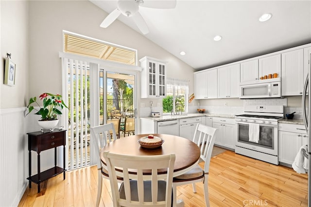 23974 Via Astuto, Murrieta, CA 92562 - kitchen with white appliances, lofted ceiling, a wainscoted wall, white cabinetry, and a ceiling fan