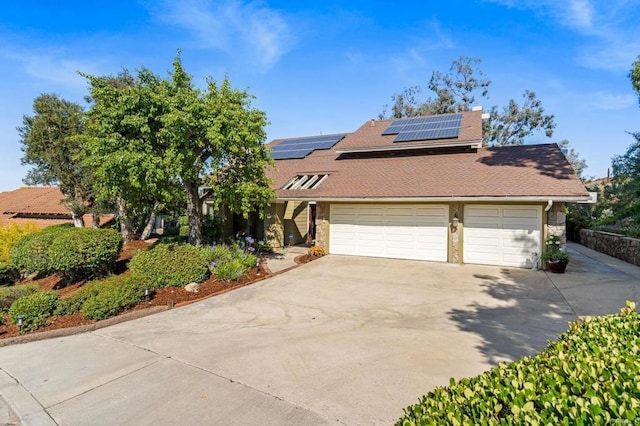 4750 Jeffer Ln, La Mesa, CA 91941 - view of front of house with concrete driveway, roof mounted solar panels, an attached garage, stone siding, and roof with shingles