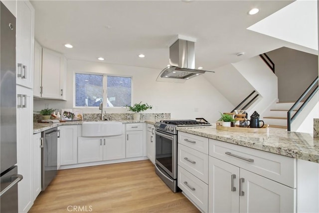 16743 Bayview Dr Unit A, Sunset Beach, CA 90742 - kitchen with stainless steel appliances, island range hood, white cabinets, light stone counters, and recessed lighting