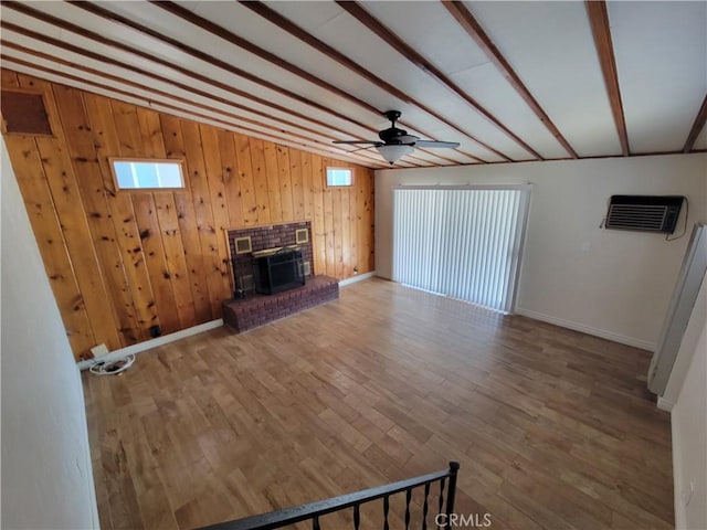 10563 Las Lunitas Ave, Tujunga, CA 91042 - unfurnished living room featuring a ceiling fan, a wall mounted air conditioner, wood finished floors, beamed ceiling, and wood walls