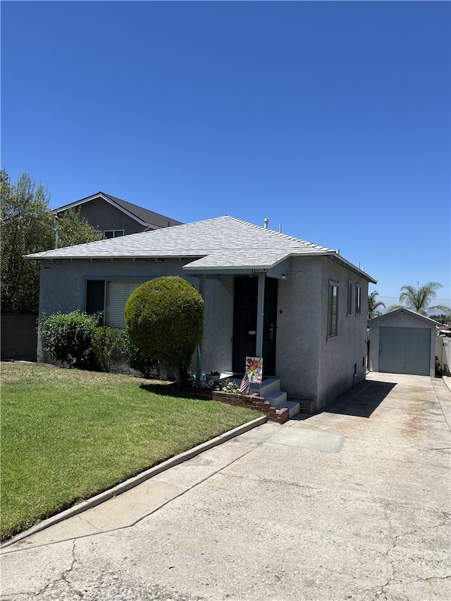 10563 Las Lunitas Ave, Tujunga, CA 91042 - view of front facade featuring an outbuilding, concrete driveway, stucco siding, a front yard, and a shingled roof