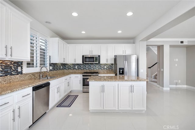 23825 Lancer Ct, Wildomar, CA 92595 - kitchen with stainless steel appliances, decorative backsplash, light stone countertops, a center island, and white cabinetry
