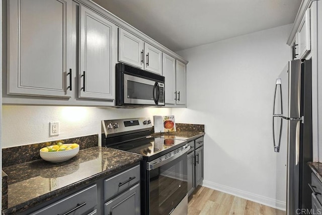 5252 Orange Ave Unit 326, San Diego, CA 92115 - kitchen featuring appliances with stainless steel finishes, gray cabinetry, light wood-style flooring, and dark stone countertops
