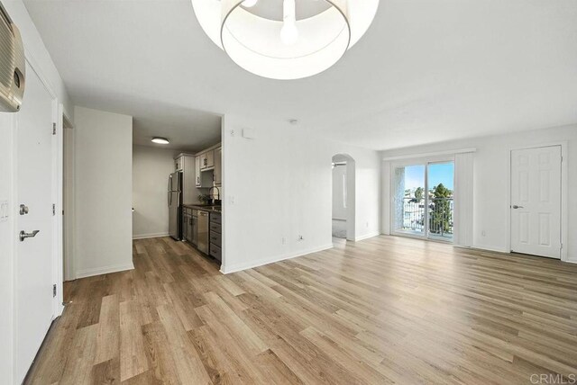 5252 Orange Ave Unit 326, San Diego, CA 92115 - unfurnished living room featuring arched walkways and light wood finished floors