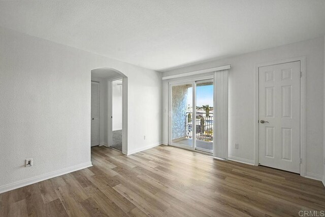 5252 Orange Ave Unit 326, San Diego, CA 92115 - spare room featuring arched walkways and wood finished floors