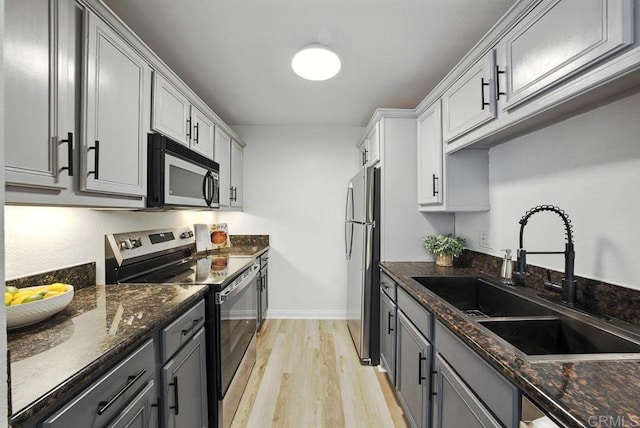 5252 Orange Ave Unit 326, San Diego, CA 92115 - kitchen with appliances with stainless steel finishes, light wood-style flooring, dark stone counters, and gray cabinets