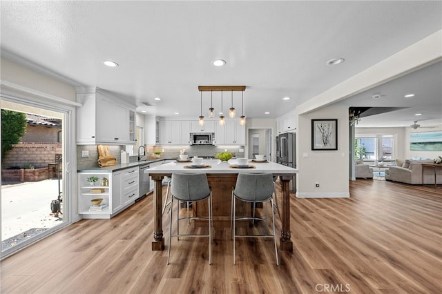 2777 Shadow Canyon Cir, Norco, CA 92860 - kitchen featuring appliances with stainless steel finishes, a breakfast bar area, light wood-type flooring, white cabinetry, and recessed lighting