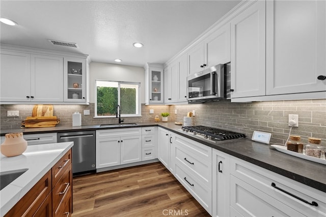 2777 Shadow Canyon Cir, Norco, CA 92860 - kitchen with appliances with stainless steel finishes, white cabinets, tasteful backsplash, dark wood finished floors, and recessed lighting