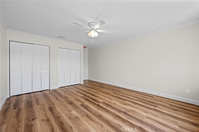 2777 Shadow Canyon Cir, Norco, CA 92860 - unfurnished bedroom with multiple closets, crown molding, wood finished floors, and ceiling fan