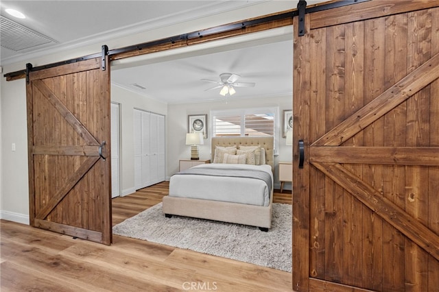 2777 Shadow Canyon Cir, Norco, CA 92860 - bedroom featuring a barn door, crown molding, wood finished floors, and ceiling fan