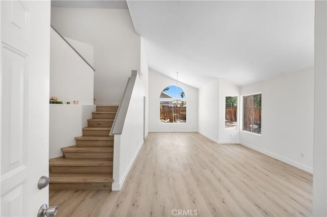 39524 Hawthorne St, Palmdale, CA 93551 - unfurnished living room with wood finished floors, stairway, and vaulted ceiling