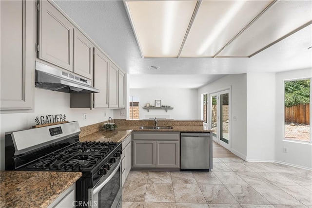 39524 Hawthorne St, Palmdale, CA 93551 - kitchen with stainless steel appliances, under cabinet range hood, gray cabinets, a peninsula, and dark stone countertops