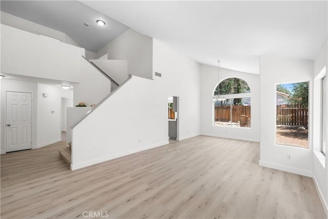39524 Hawthorne St, Palmdale, CA 93551 - unfurnished living room featuring stairs, light wood-style flooring, and high vaulted ceiling