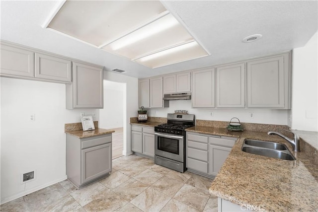 39524 Hawthorne St, Palmdale, CA 93551 - kitchen featuring stainless steel gas stove, gray cabinetry, under cabinet range hood, and light stone counters