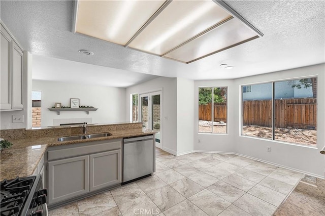 39524 Hawthorne St, Palmdale, CA 93551 - kitchen featuring dishwasher, gray cabinetry, gas range, a peninsula, and a textured ceiling