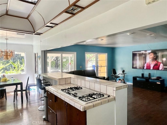 14712 Hiawatha St, San Fernando, CA 91345 - kitchen with tile counters, white gas stovetop, open floor plan, a chandelier, and dark brown cabinets