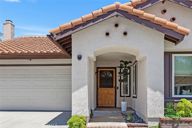 7 Via Olorosa, Rancho Santa Margarita, CA 92688 - property entrance featuring a tile roof, stucco siding, an attached garage, and a chimney