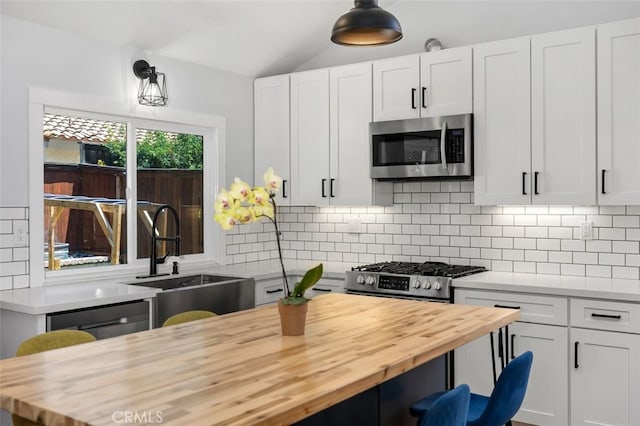 7 Via Olorosa, Rancho Santa Margarita, CA 92688 - kitchen featuring stainless steel appliances, butcher block counters, tasteful backsplash, white cabinetry, and lofted ceiling