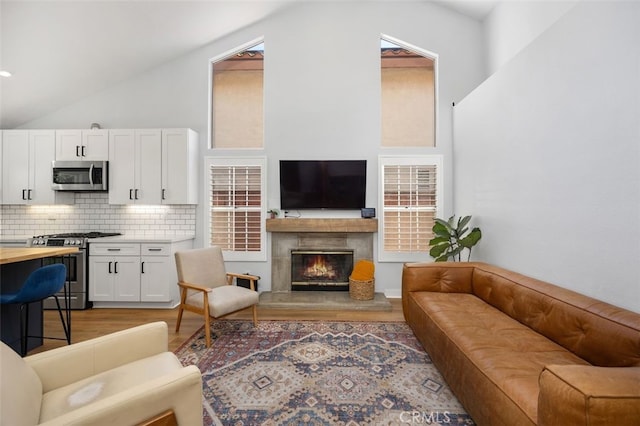 7 Via Olorosa, Rancho Santa Margarita, CA 92688 - living area featuring vaulted ceiling, light wood-style flooring, and a high end fireplace