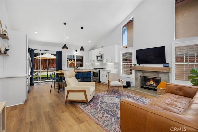 7 Via Olorosa, Rancho Santa Margarita, CA 92688 - living room with a glass covered fireplace, light wood-type flooring, recessed lighting, and high vaulted ceiling