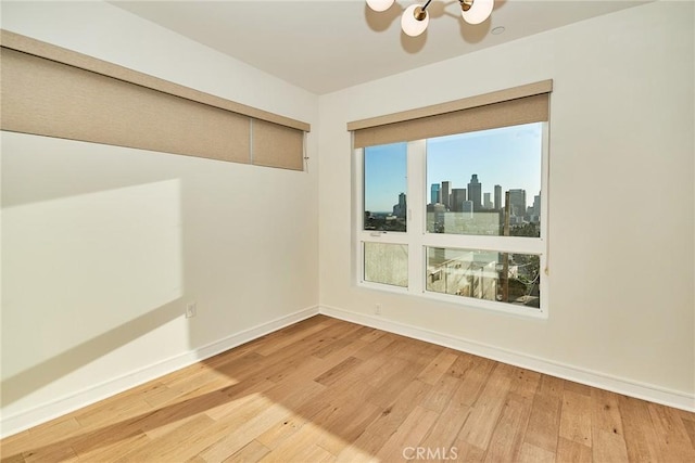 1050 N Joels Pl, Los Angeles, CA 90012 - unfurnished room with wood finished floors, a chandelier, and a skyline view