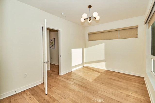 1050 N Joels Pl, Los Angeles, CA 90012 - spare room with a chandelier, light wood-type flooring, and a smoke detector