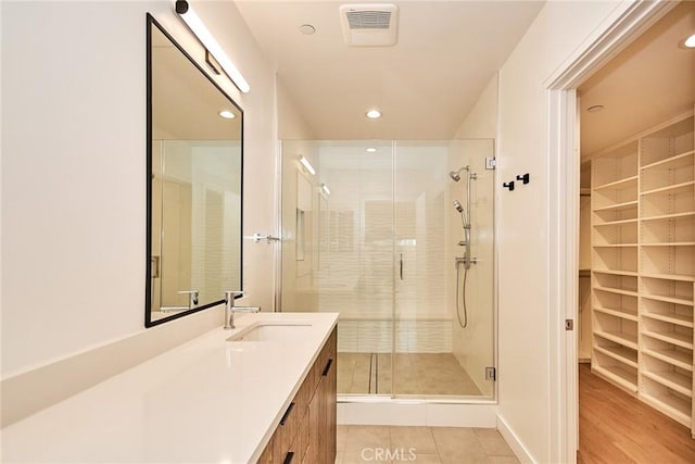 1050 N Joels Pl, Los Angeles, CA 90012 - full bathroom featuring vanity, a shower stall, a spacious closet, recessed lighting, and tile patterned flooring