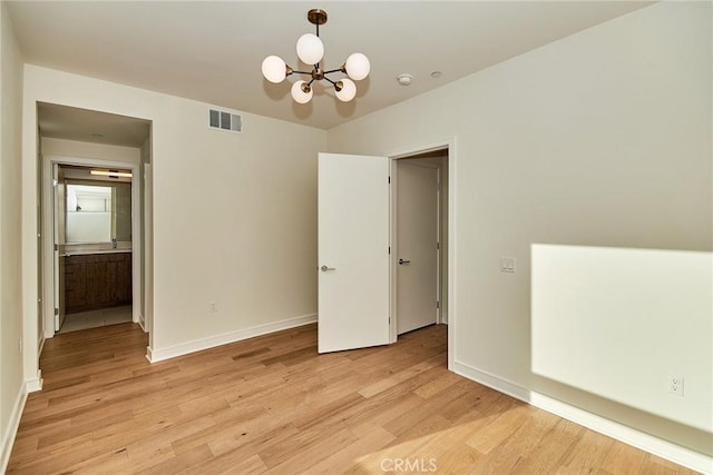1050 N Joels Pl, Los Angeles, CA 90012 - unfurnished room featuring light wood finished floors, a chandelier, and a smoke detector