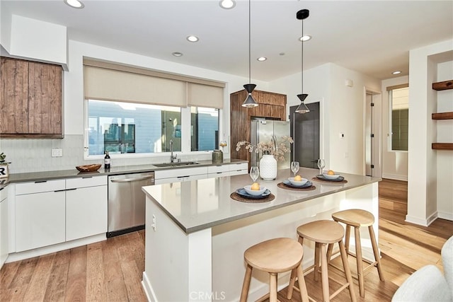 1050 N Joels Pl, Los Angeles, CA 90012 - kitchen with stainless steel appliances, a kitchen bar, light wood-style floors, modern cabinets, and recessed lighting