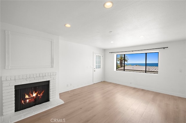 33771 Copper Lantern St, Dana Point, CA 92629 - unfurnished living room with a brick fireplace, recessed lighting, and wood finished floors