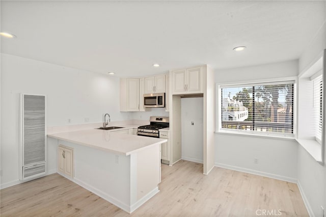 33771 Copper Lantern St, Dana Point, CA 92629 - kitchen featuring stainless steel appliances, a heating unit, a peninsula, light wood-type flooring, and plenty of natural light