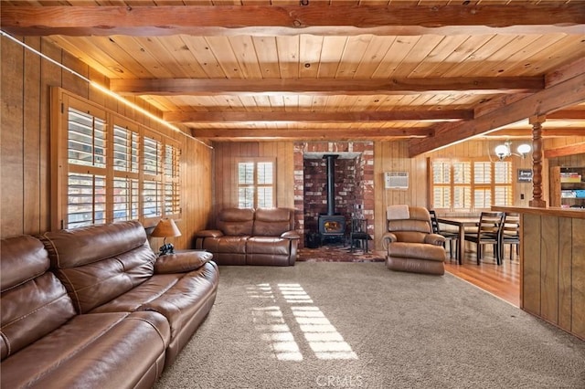 130 Maple Ln, Sugarloaf, CA 92386 - carpeted living area featuring a wood stove, wood walls, a chandelier, a wood ceiling with exposed beams, and a wall mounted air conditioner