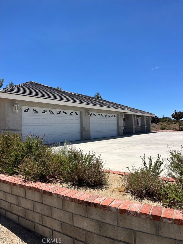 325 Canyon Rd, Pinon Hills, CA 92372 - view of front of house featuring driveway, stucco siding, and an attached garage