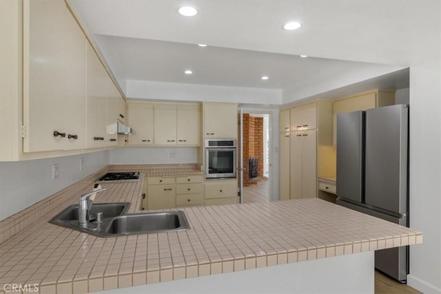 6 Mandrake Way, Irvine, CA 92612 - kitchen with cream cabinetry, appliances with stainless steel finishes, a peninsula, under cabinet range hood, and recessed lighting