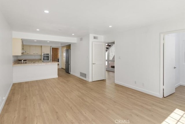 6 Mandrake Way, Irvine, CA 92612 - unfurnished living room featuring light wood finished floors, recessed lighting, and stairs