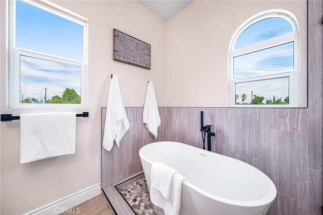 2709 Cogswell Rd Unit A, El Monte, CA 91732 - full bathroom featuring a freestanding bath, tile walls, and a wainscoted wall