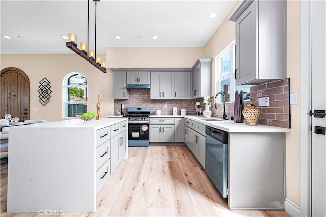 2709 Cogswell Rd Unit A, El Monte, CA 91732 - kitchen featuring gray cabinets, stainless steel appliances, light wood finished floors, backsplash, and light countertops