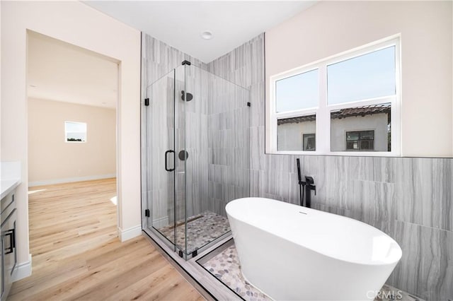 2709 Cogswell Rd Unit B, El Monte, CA 91732 - full bath featuring a freestanding tub, a stall shower, tile walls, vanity, and wood finished floors