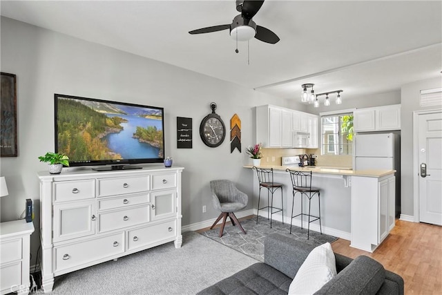 20191 Cape Coral Ln Unit 3-206, Huntington Beach, CA 92646 - living area featuring ceiling fan and light wood-style floors